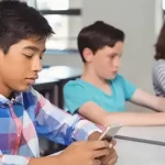 Estudiantes en un aula escolar utilizando dispositivos digitales en Tijuana