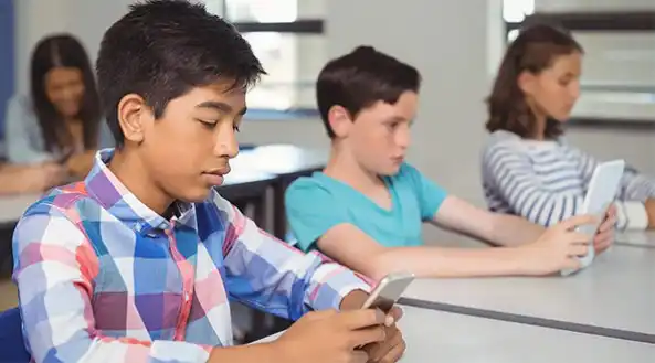 Estudiantes en un aula escolar utilizando dispositivos digitales en Tijuana